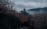 A ghostly apparition floating above an old, abandoned castle.