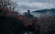 A haunting scene of an abandoned castle shrouded in mist.