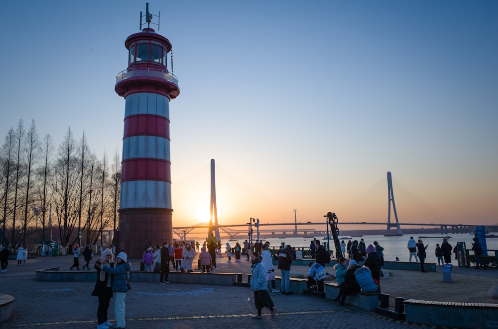 people walking near red and white tower during daytime