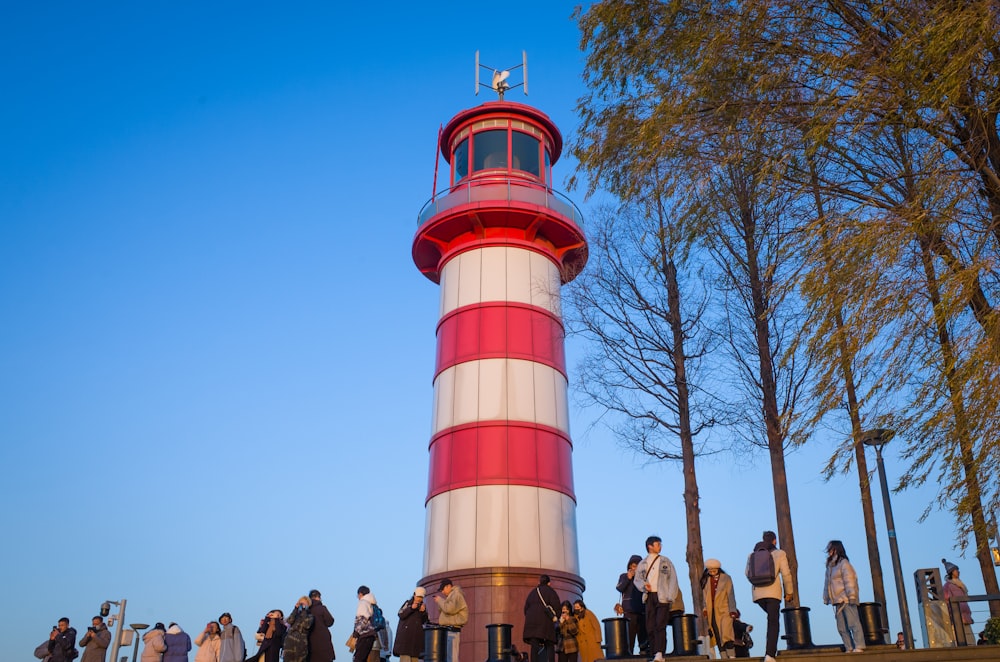 people standing near red and white tower during daytime