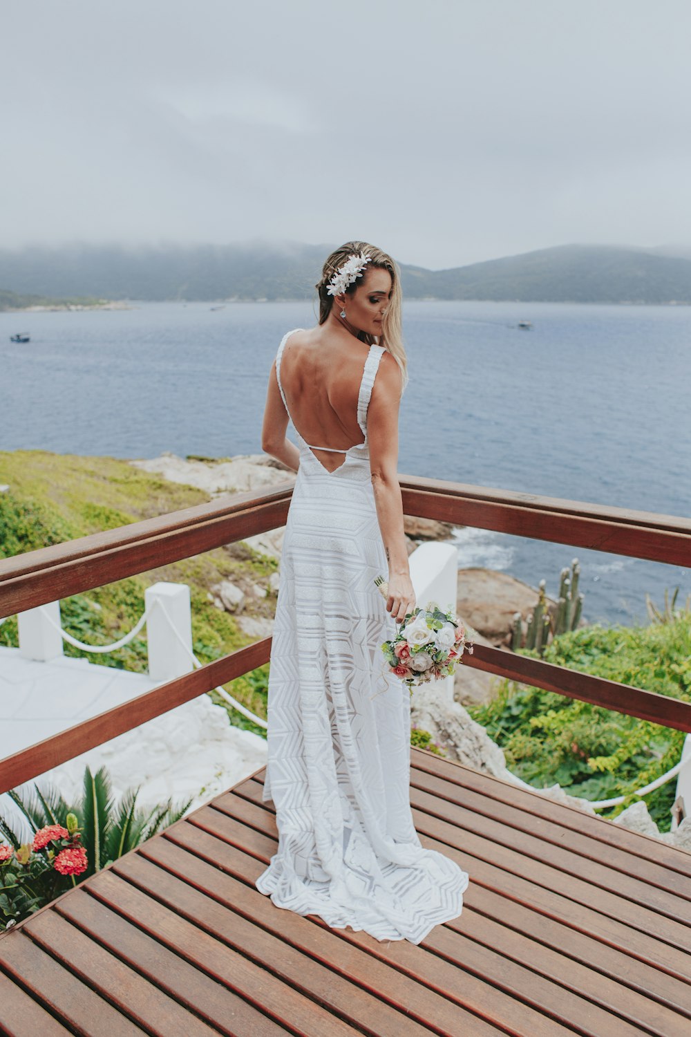 woman in white spaghetti strap dress standing on brown wooden dock during daytime