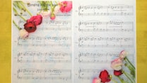 A sheet of music titled 'Longing for the past' with floral decoration on the left and bottom edges. The page is divided into sections with musical notations for a piano piece, labeled as an easy version by Nicoline van Goor. The background features a subtle watercolor texture, enhancing the artistic feel.