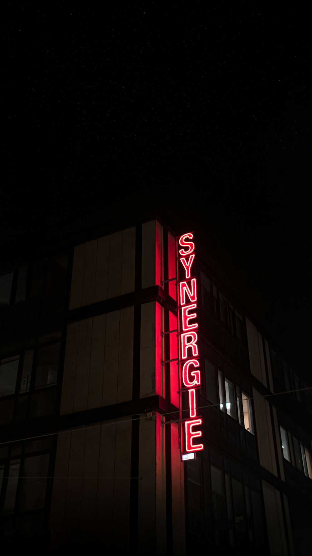 a tall building with a neon sign on it's side