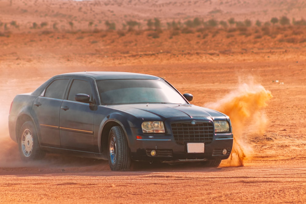 black sedan on brown field during daytime