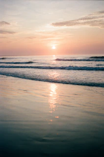 sea waves crashing on shore during sunset