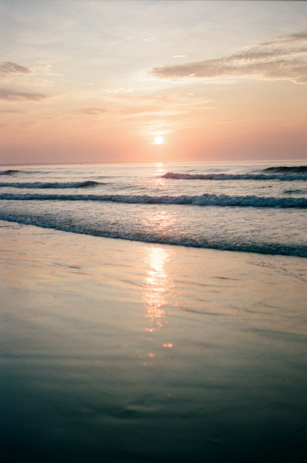 sea waves crashing on shore during sunset