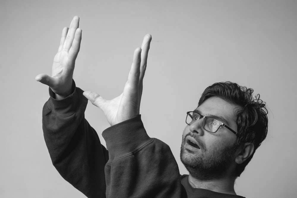 man in black framed eyeglasses and black long sleeve shirt