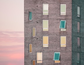 A skilled worker installing modern window shades on a sunny building facade