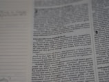 A close-up of a book page with text, focusing on a passage that mentions Joshua, the servant of the Lord, and his burial. The text discusses events related to the Israelites and includes religious themes. Dotted lines are visible on the left, possibly for notes or annotations.