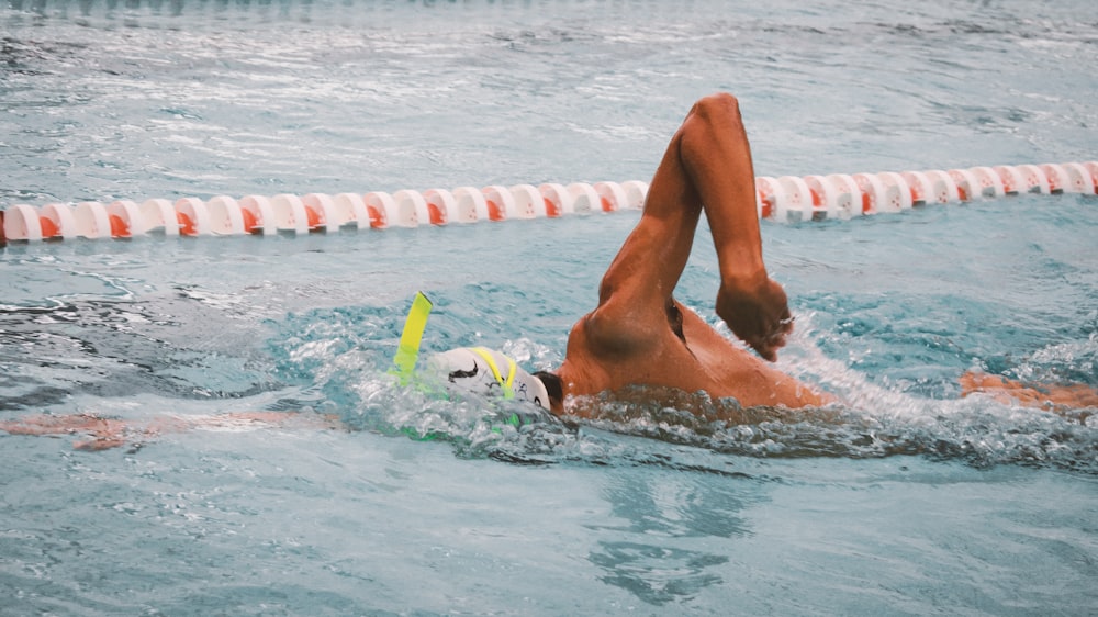 a person swimming in a pool with a ball
