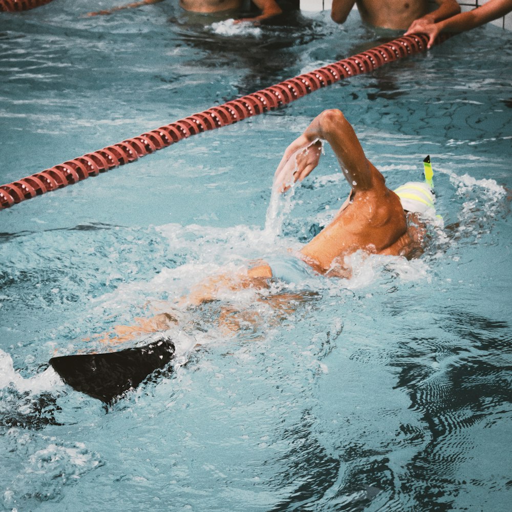 a man swimming in a pool with a frisbee