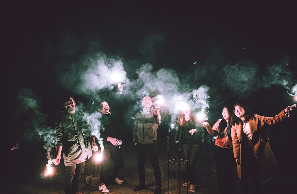 group of people standing on stage with green smoke