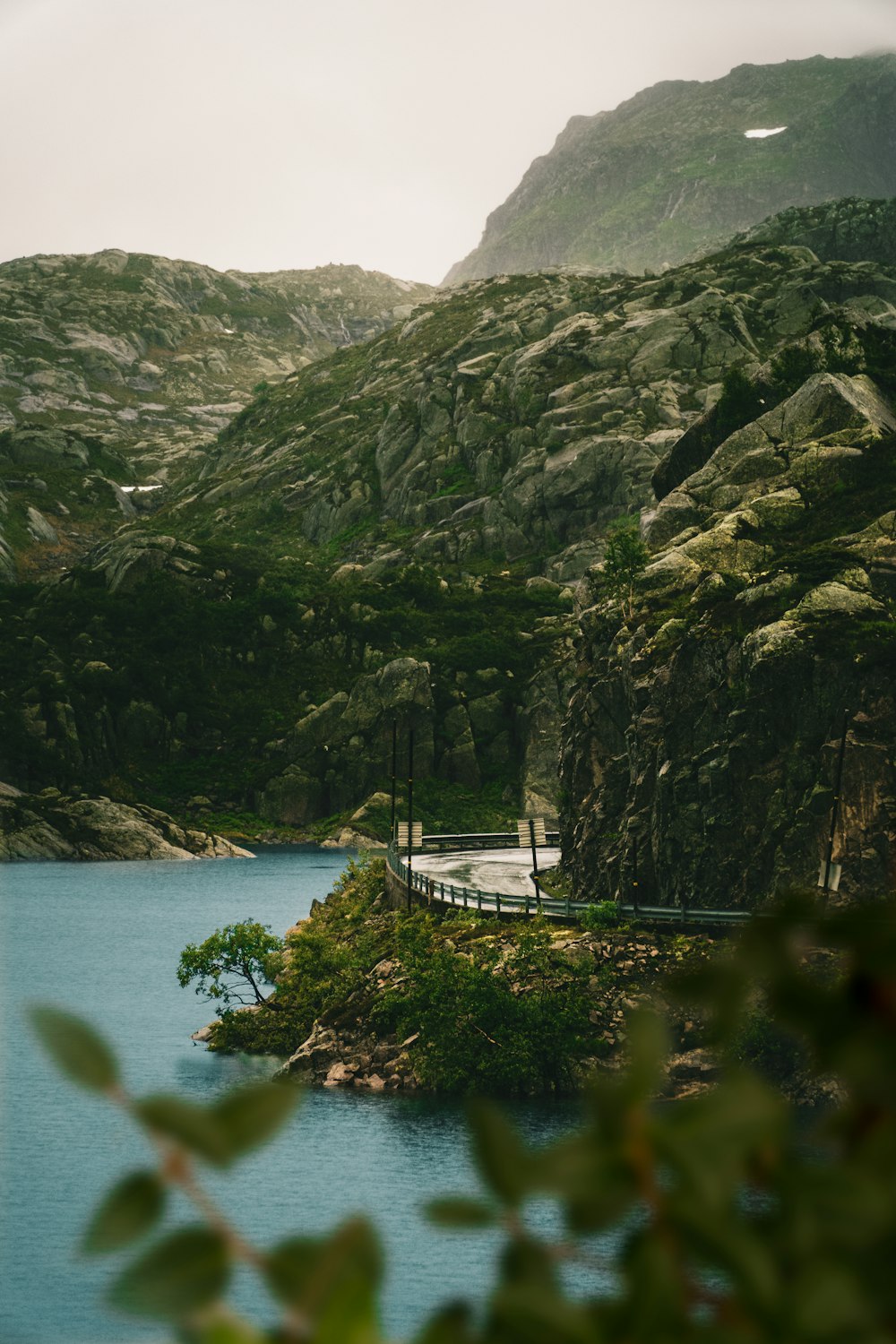 white boat on body of water near mountain during daytime