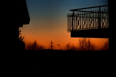 Close-up of a balcony overlooking Pune’s skyline at sunset.