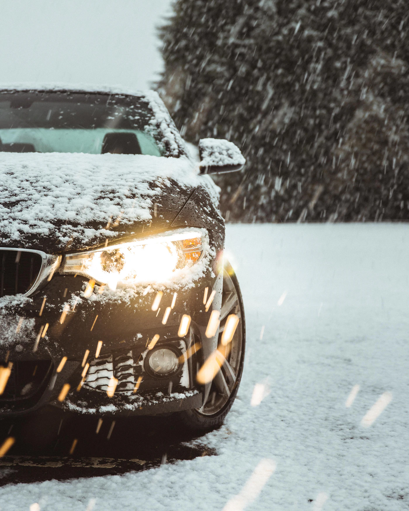 A dark car driving on a snow covered road