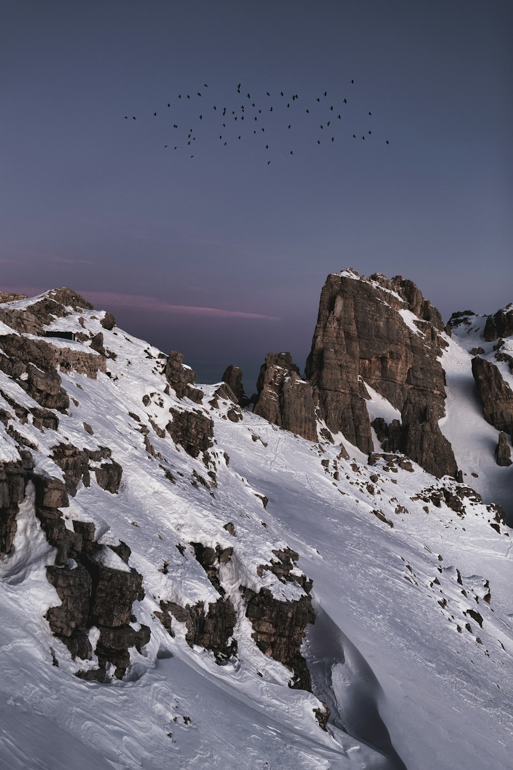 brown rocky mountain covered by snow under blue sky during daytime