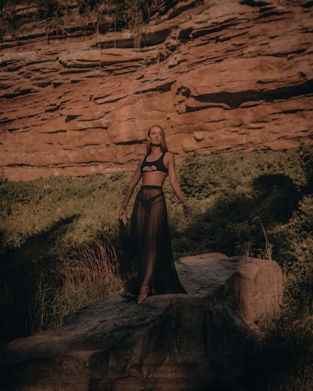 woman in brown dress standing on brown rock formation during daytime
