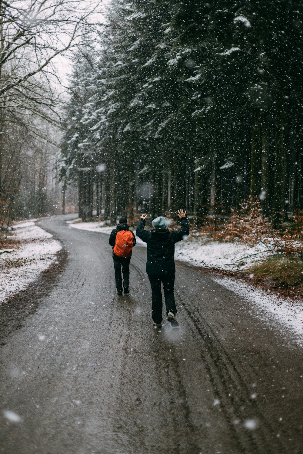 person in black jacket and black pants walking on road during daytime