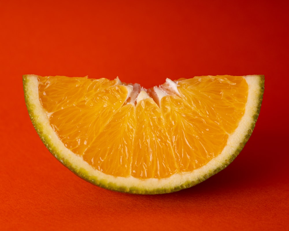 Fruits orange tranchés sur textile rouge