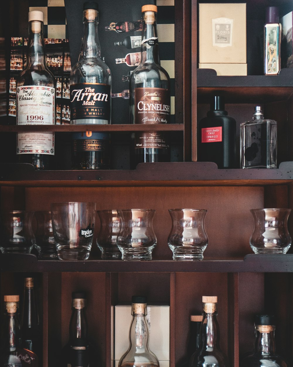 clear drinking glass on brown wooden shelf