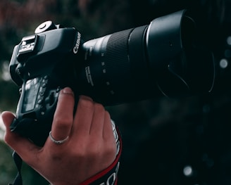 person holding black canon dslr camera