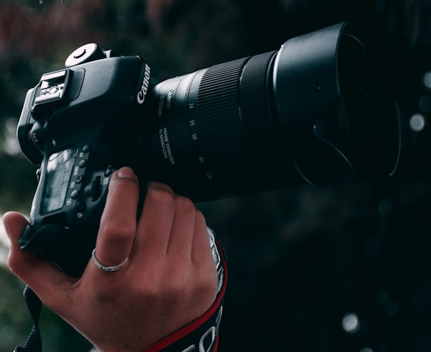 person holding black canon dslr camera