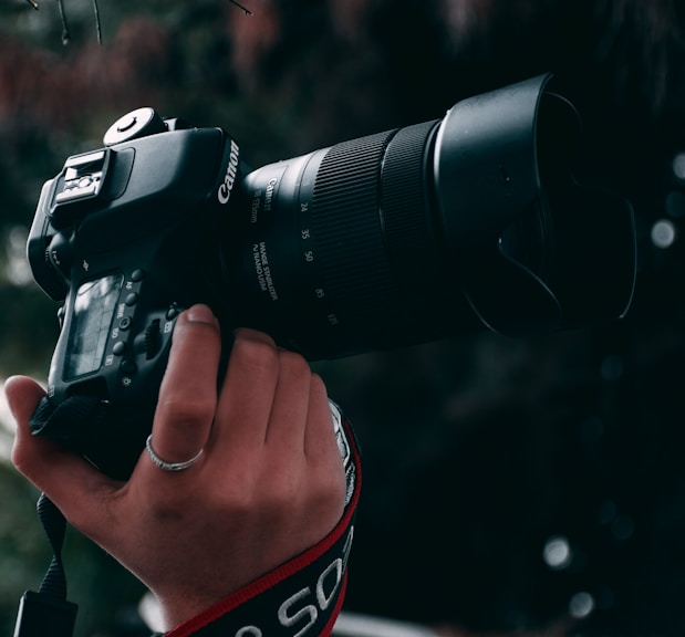 person holding black canon dslr camera