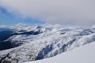 snow covered mountain under cloudy sky during daytime