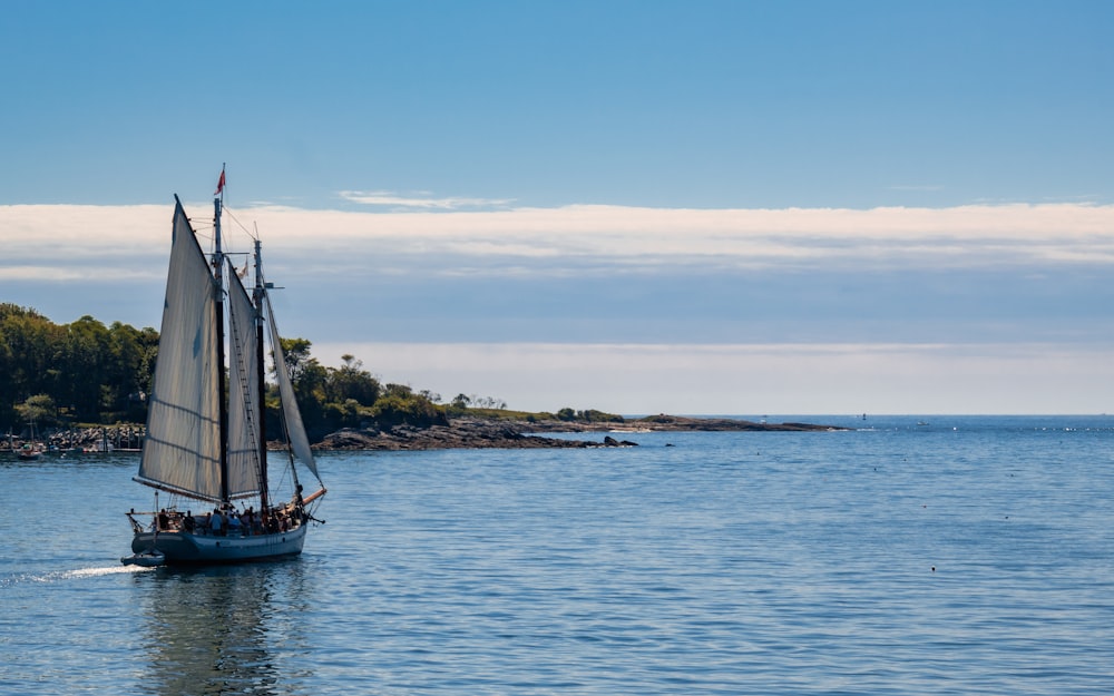 black sail boat on sea during daytime