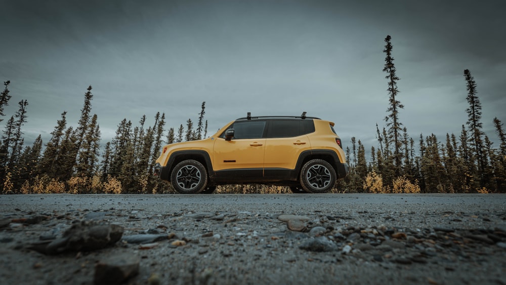 yellow car on gray dirt road during daytime