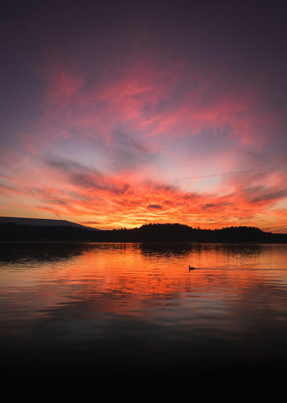 Cuerpo de agua bajo cielo nublado durante la puesta del sol