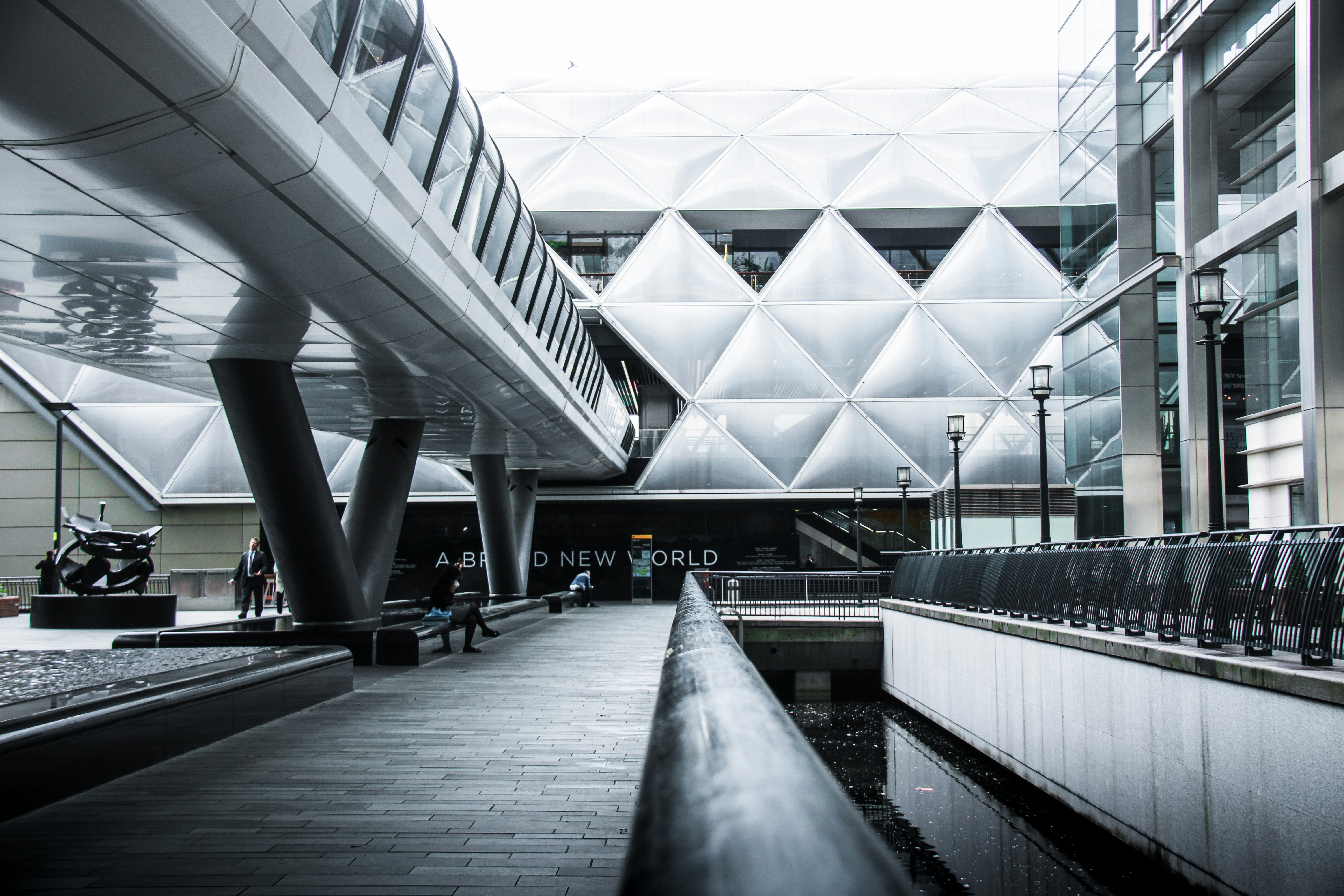 a train station with a walkway and a water feature