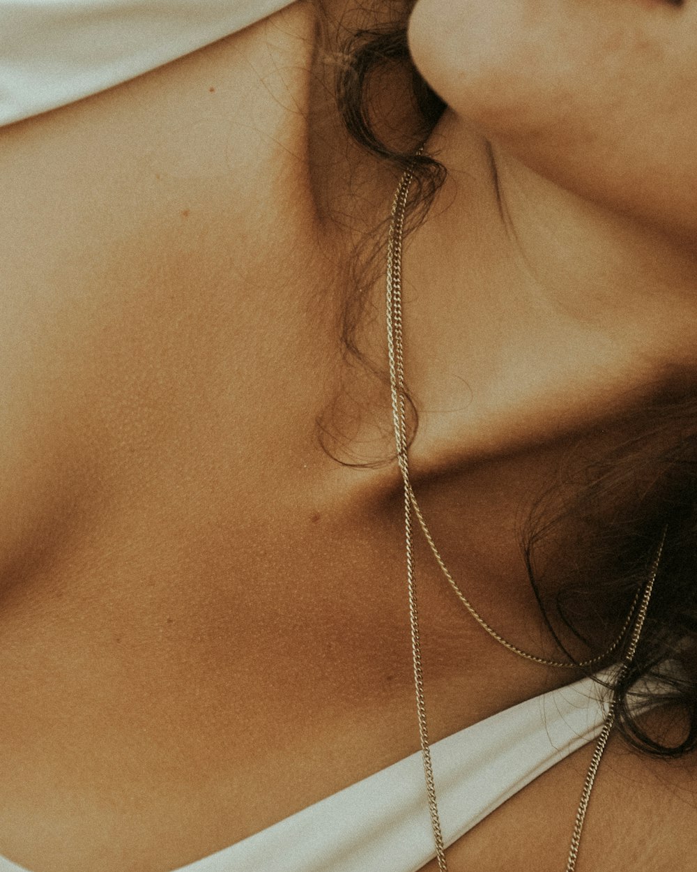 woman in white tank top wearing silver necklace