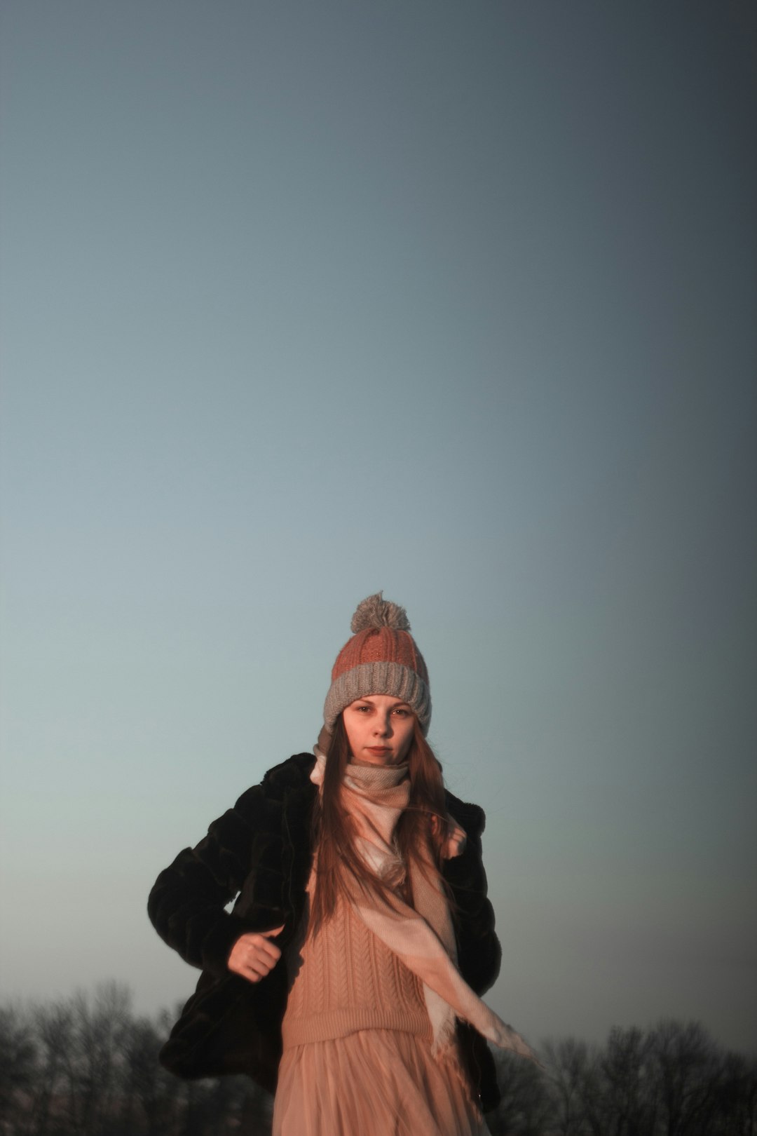 woman in black jacket wearing brown knit cap