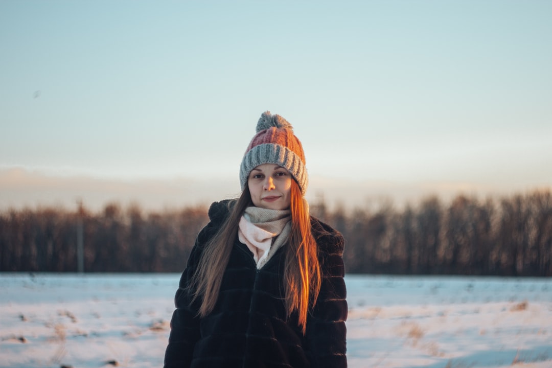 woman in black jacket standing on snow covered ground during daytime