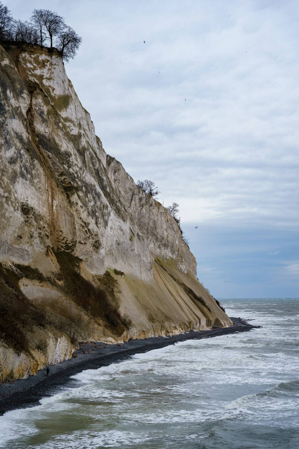 Brauner felsiger Berg am Meer tagsüber