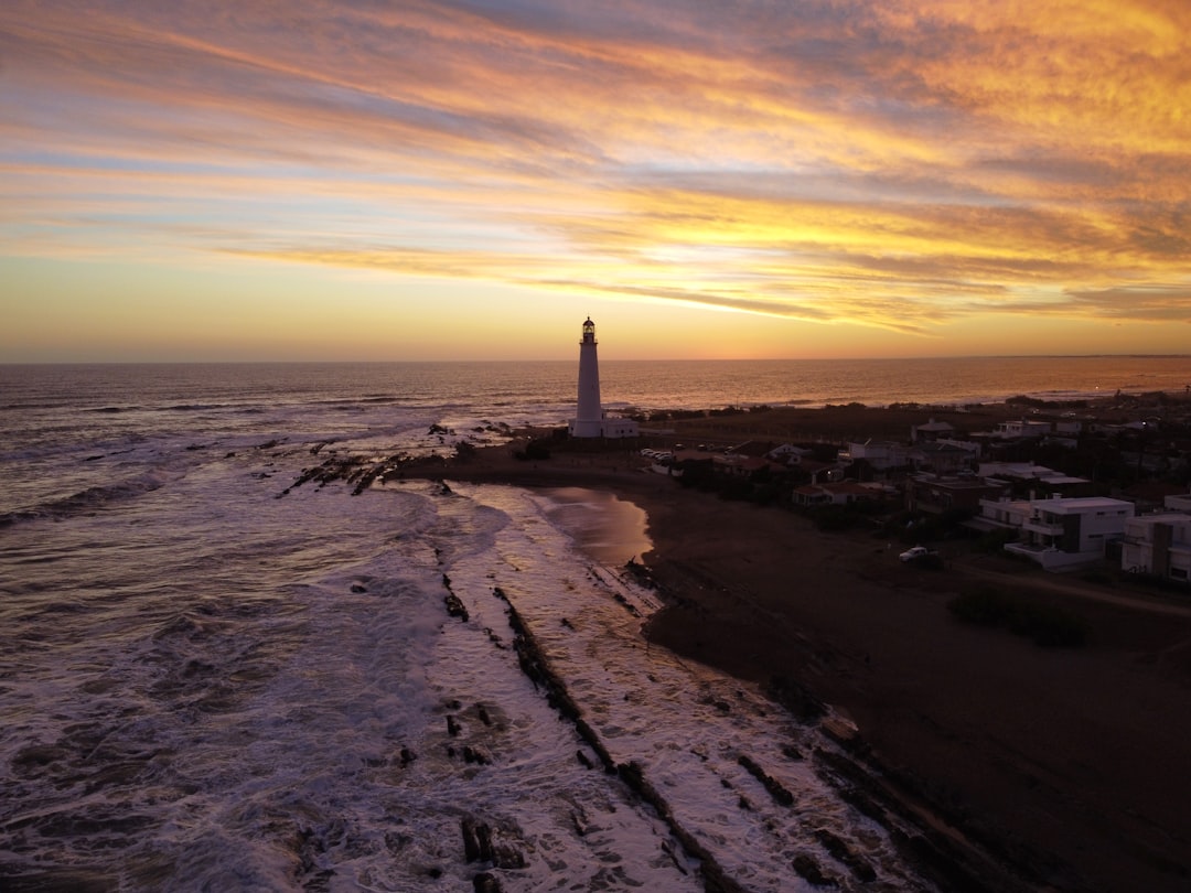 white lighthouse on gray sand during sunset