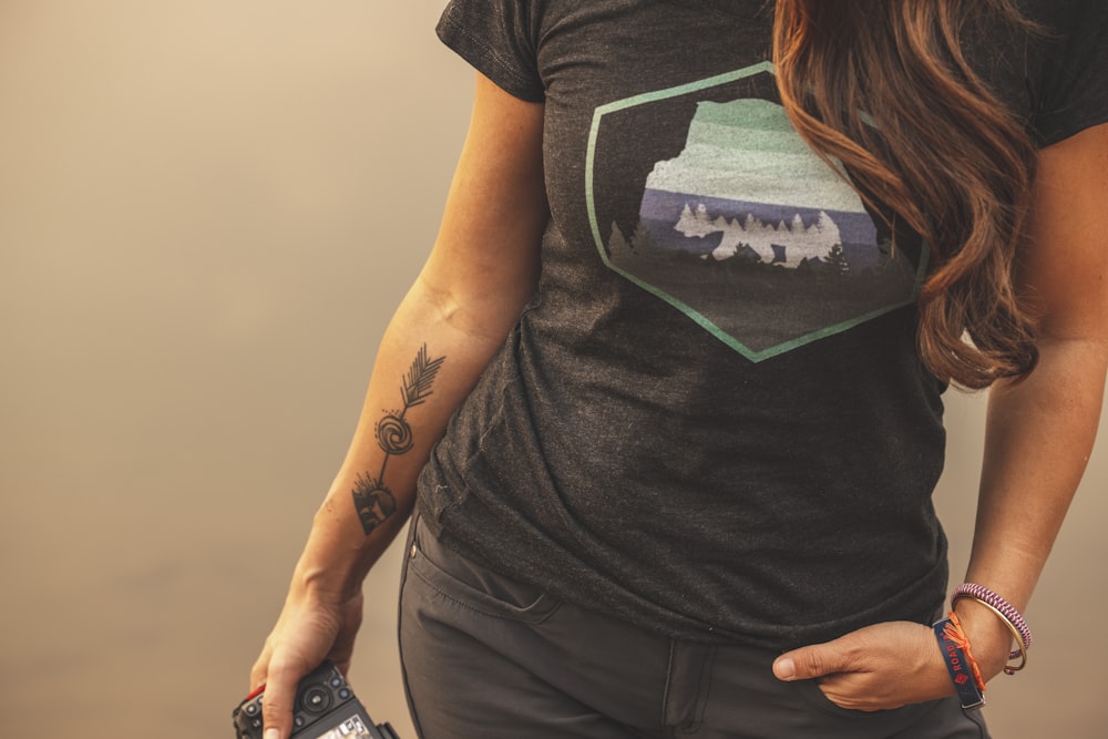 woman in black and white t-shirt and gray denim shorts holding black remote control