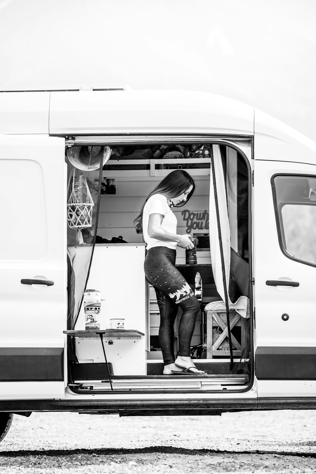 woman in white t-shirt and black shorts sitting on white van