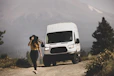 woman in black tank top and white shorts standing beside white van during daytime