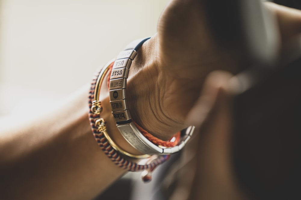 person wearing silver and blue bracelets