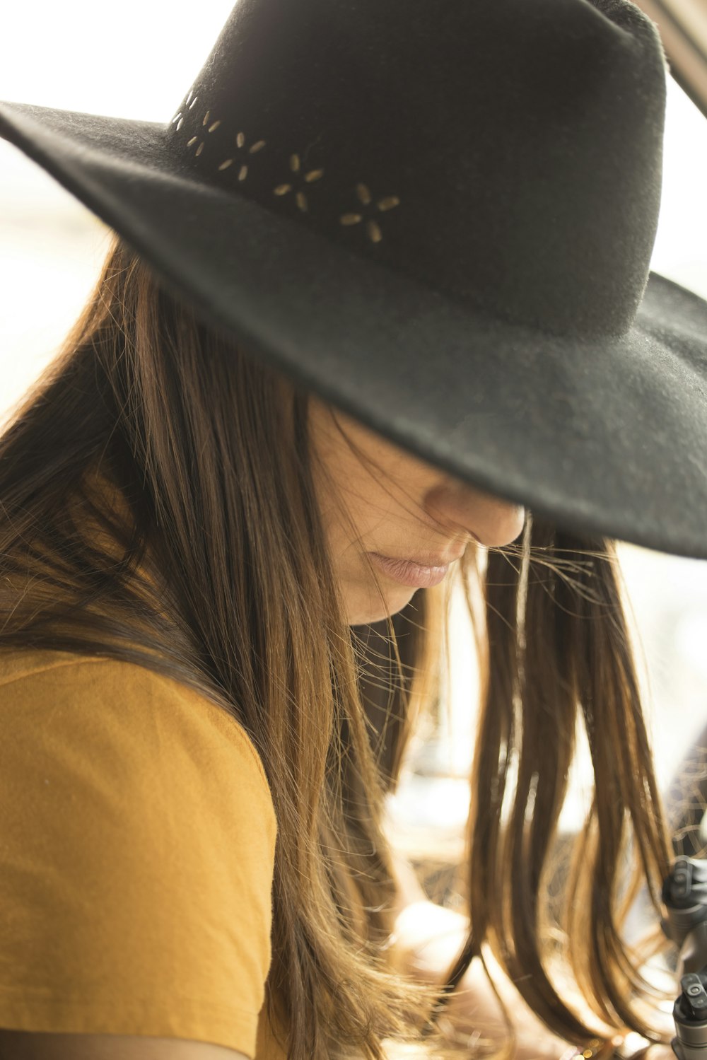 woman in black hat and yellow shirt