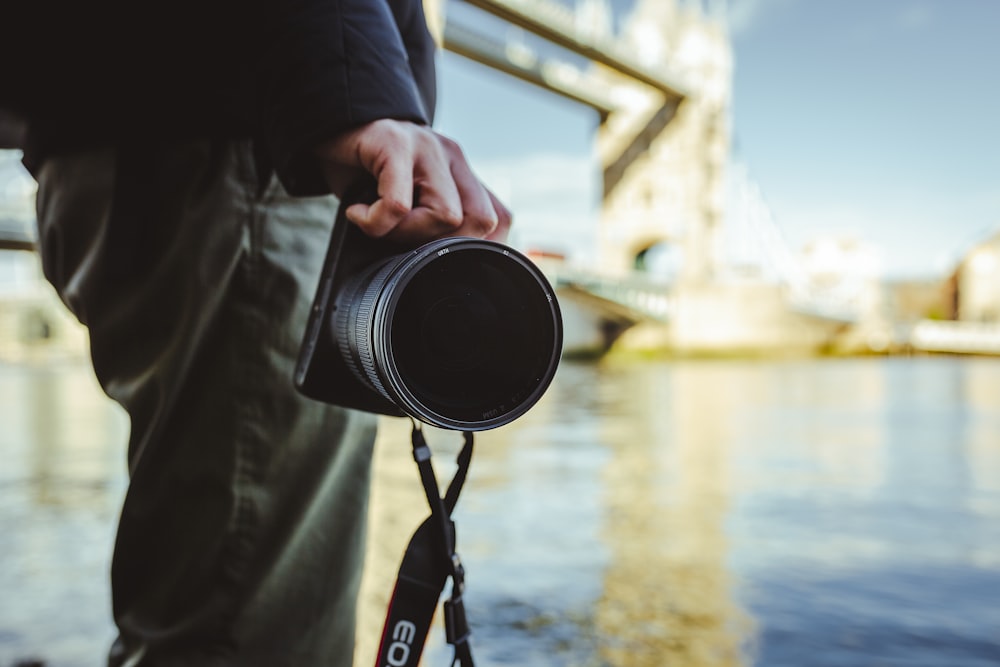 person holding black and silver camera