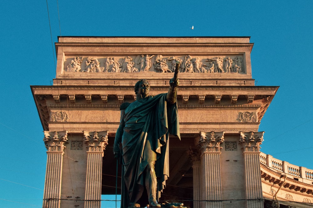 statue of man holding book