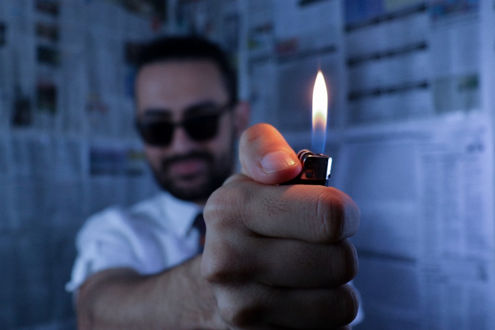 man in white shirt holding lighter