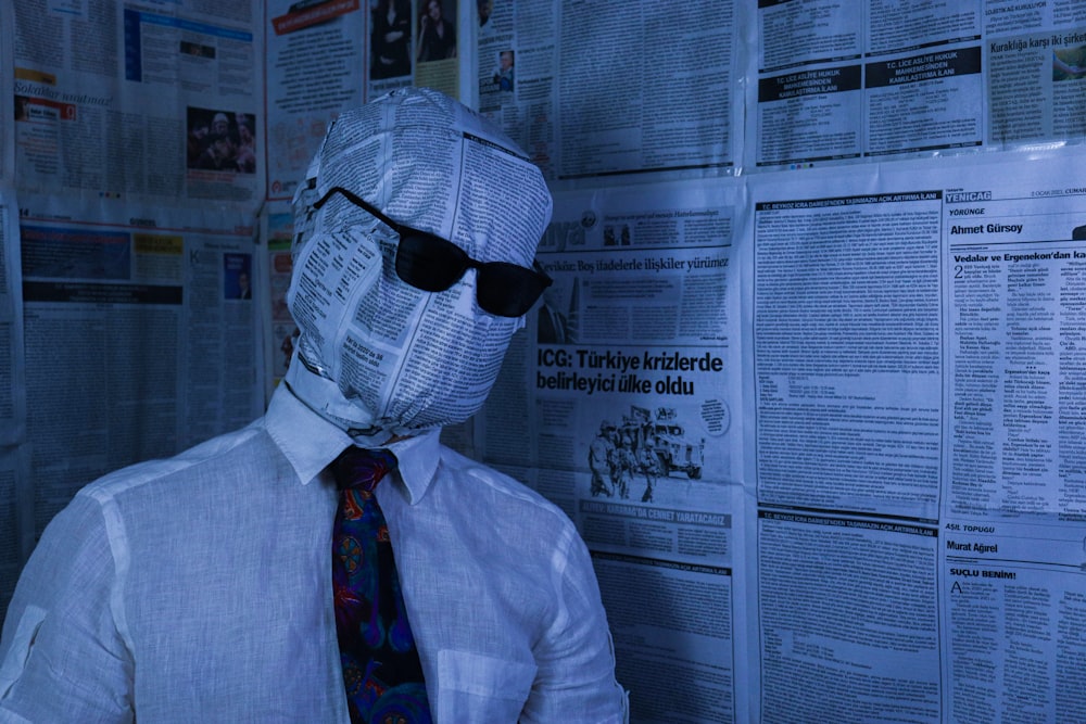 man in white dress shirt wearing black sunglasses and black and white plaid necktie