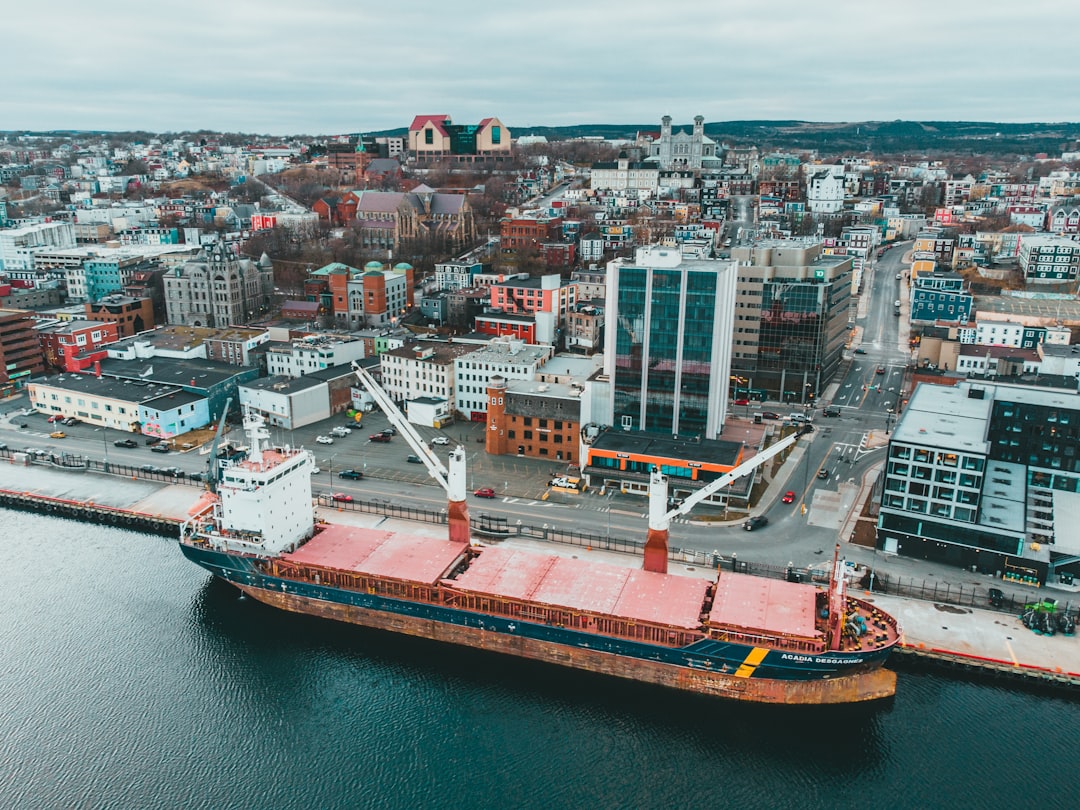 red and white ship on sea near city buildings during daytime