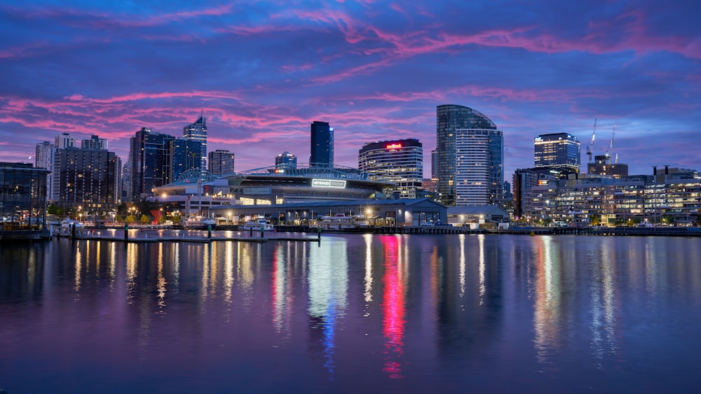 city skyline across body of water during night time