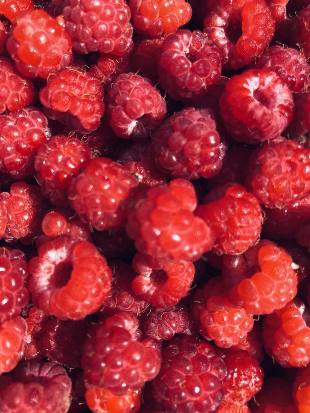 a bunch of raspberries that are very ripe