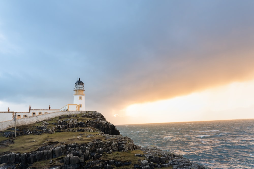 white lighthouse near body of water during daytime